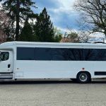Spacious interior of a 35-passenger Atlanta party bus with plush seating, LED lights, and a dance pole.