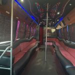 Interior of a 35-passenger Atlanta Party Bus with plush seating, LED lights, and a dance pole.