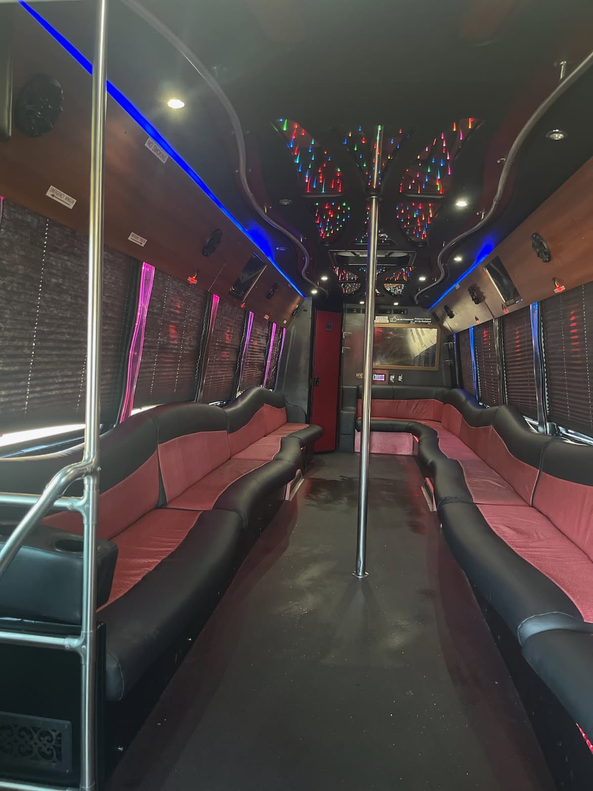 Interior of a 35-passenger Atlanta Party Bus with plush seating, LED lights, and a dance pole.