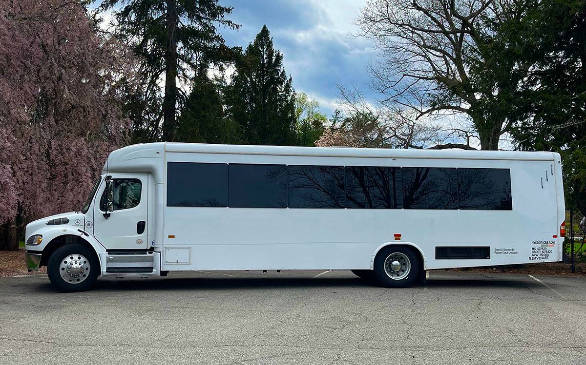 Spacious interior of a 35-passenger Atlanta party bus with plush seating, LED lights, and a dance pole.