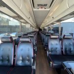 A modern, clean 56 passenger standard coach shuttle bus, perfect for large group transportation.