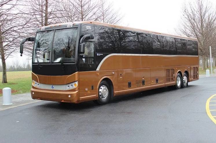 A side-view of a full-size, 56-passenger commercial coach bus with tinted windows and a clean, white exterior.